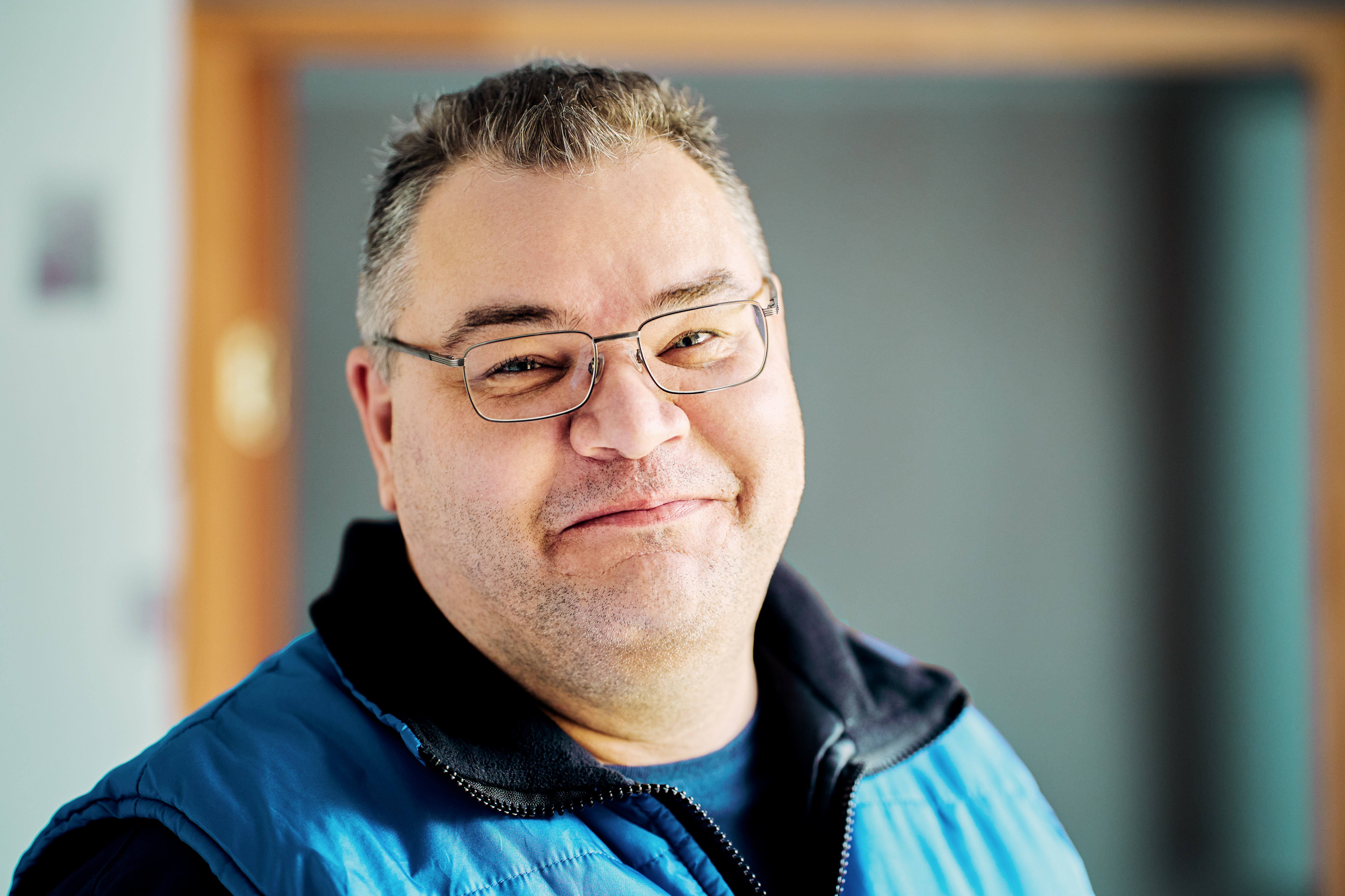 une homme souriant avec des lunettes