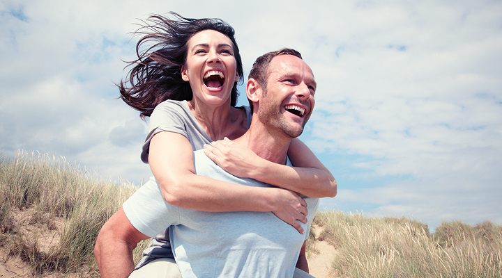 Un couple souriant en plein air.