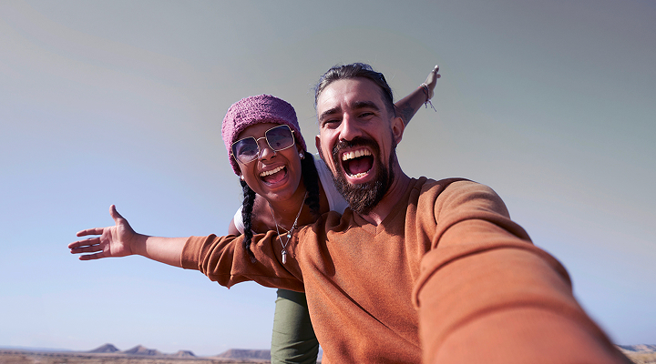 Un couple souriant en plein air.