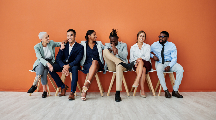 Un groupe diversifié de six personnes, assis et souriant.